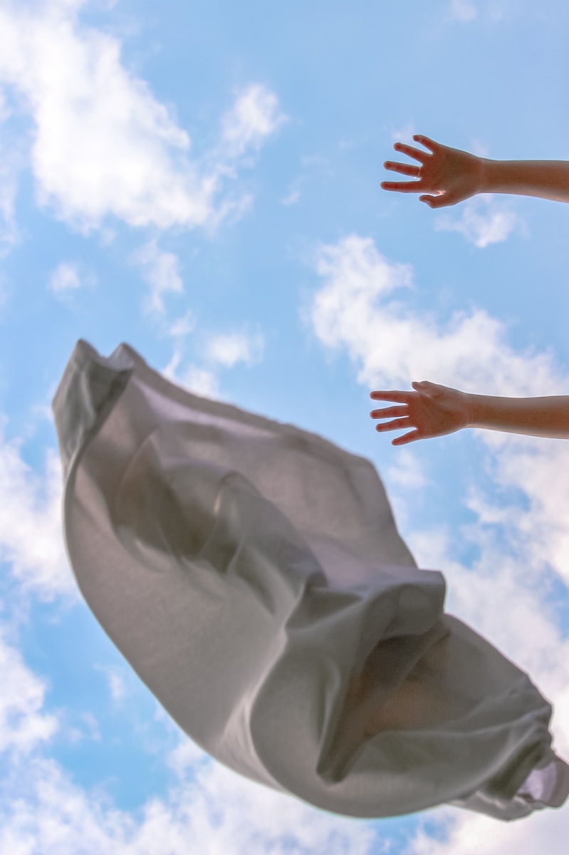 persons hand on white textile